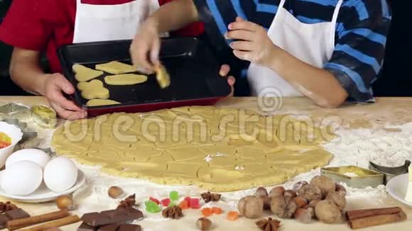 两个孩子把面团放在圣诞饼干烤盘上视频的预览图