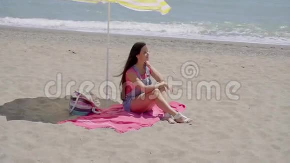 单身女人在海滩伞下放松视频的预览图