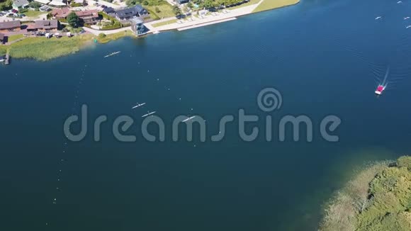 划船训练空中人们在湖上的岛屿之间划桨在阳光明媚的日子里闪烁着蓝色的水鸟瞰图视频的预览图