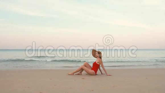 穿着红色泳衣和帽子的快乐女旅行者在完美的海滩上放松视频的预览图