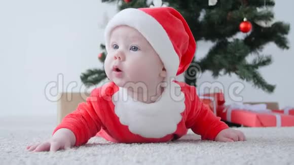 可爱的宝宝穿着圣诞老人的服装看着视频的预览图