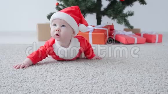 可爱的宝宝穿着圣诞老人的服装看着视频的预览图