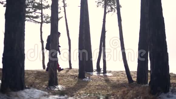 旅行者在森林里徒步旅行在森林里背包徒步旅行的女性慢动作视频的预览图