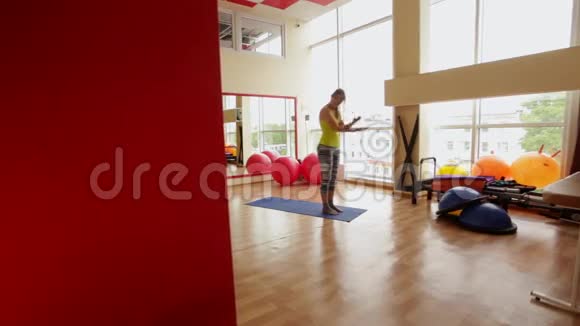 年轻女子健身教练在健身房里表演阿萨纳迎接太阳视频的预览图