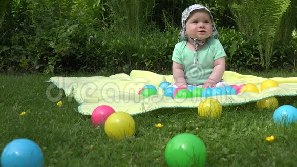 健康的宝宝在草地上花了很多时间在格子花球上4K视频的预览图