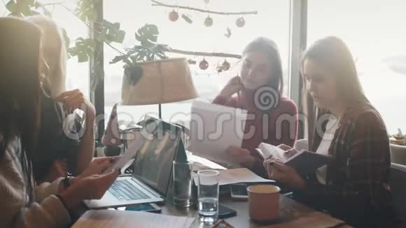 吸引了两个女商人在咖啡店讨论文件和使用笔记本电脑视频的预览图
