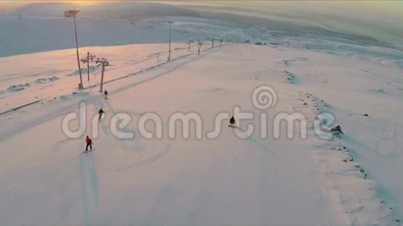 日落时滑雪者和滑雪板的鸟瞰图视频的预览图