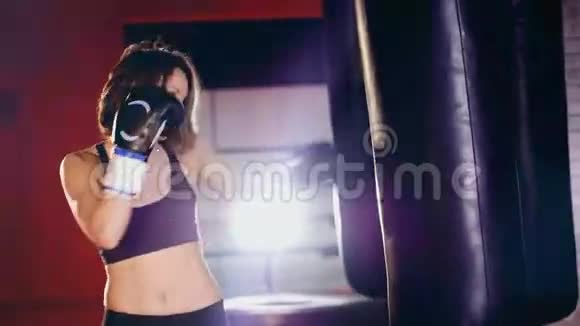 女子拳击手在健身房训练拳击袋视频的预览图