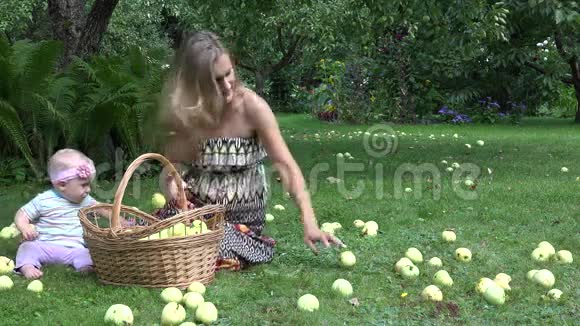 村民妇女穿着衣服她的一岁小女儿摘苹果到柳条篮子4K视频的预览图