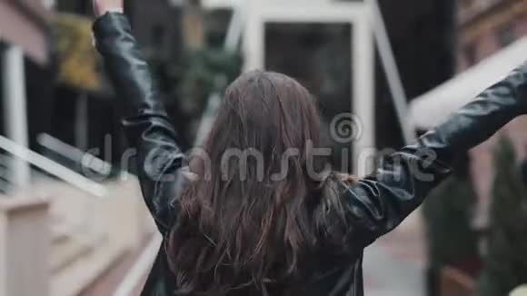 快乐的年轻女子走在街上跳舞慢动作视频的预览图