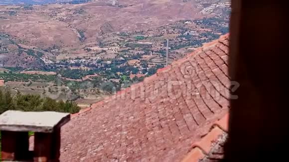 从高高的瓷砖屋顶到山谷中的村庄在青山和树木之间视频的预览图