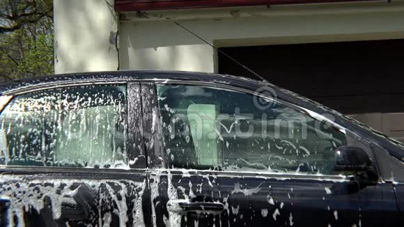 漂亮的女孩用海绵洗她的车视频的预览图