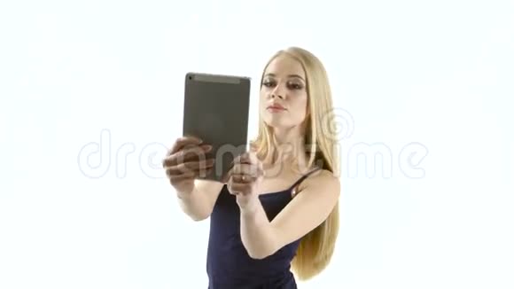 金发女孩模型在平板电脑上制作自拍照片工作室视频的预览图