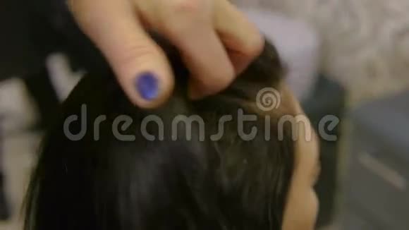 美发师在一家美容院抚摸着她的双手长发女人视频的预览图
