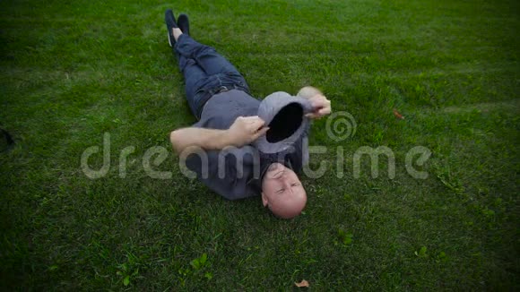 戴着帽子的人躺在公园的草地上视频的预览图