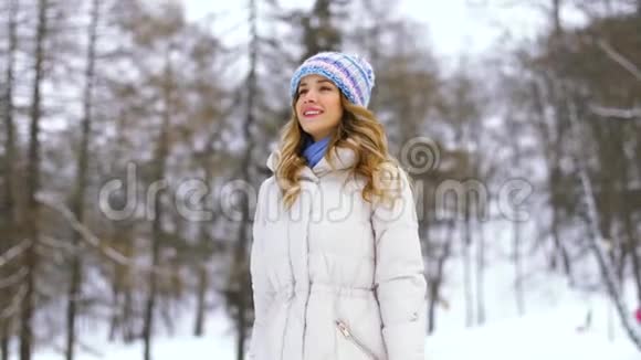 冬季森林或公园散步的快乐女人视频的预览图