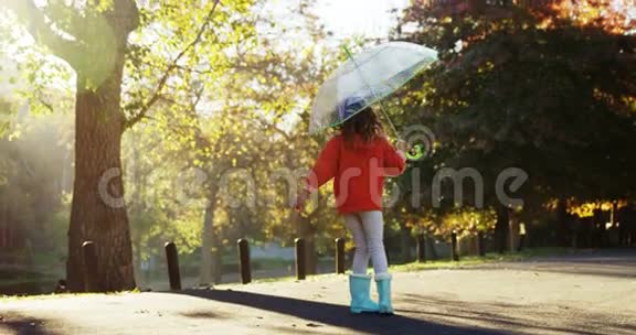 带伞在户外玩得开心的女孩视频的预览图