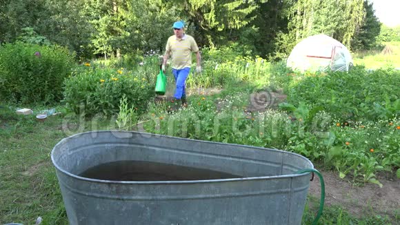 有浇水的农民可以从花园里的水桶里取水4K视频的预览图