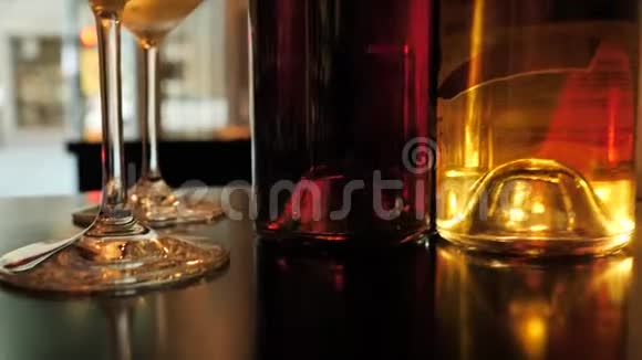 两杯香槟和不同颜色的酒瓶展览在西班牙的酒吧空间视频的预览图