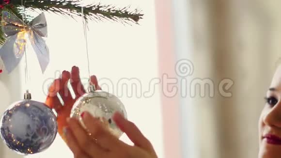 美丽的年轻女子装饰圣诞树庆祝圣诞节视频的预览图