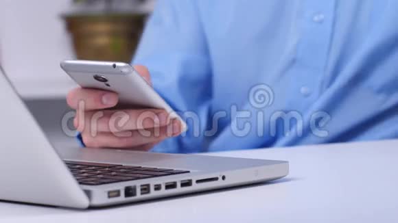 男人在办公室里用手机和笔记本电脑在线购买关门视频的预览图