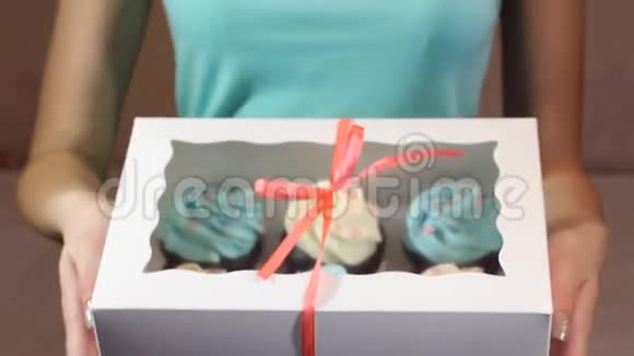 装饰礼品盒与纸杯蛋糕系在一起女性手中有一条绿松石丝带视频的预览图