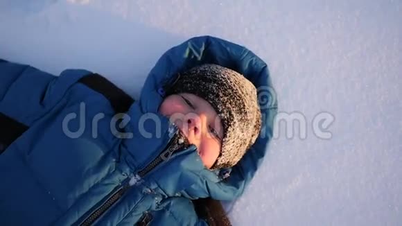 这孩子躺在雪地上微笑冬天的时候视频的预览图