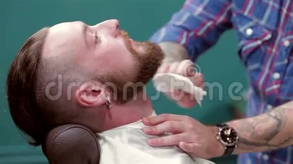 理发师刮胡子后擦拭人的脖子视频的预览图