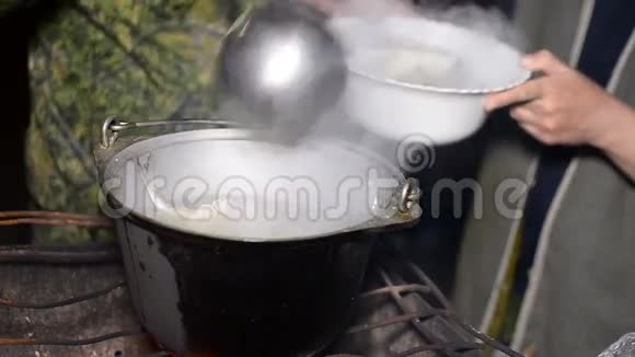 人把一个瓢建成一碗煎鱼锅汤是用火煮的视频的预览图