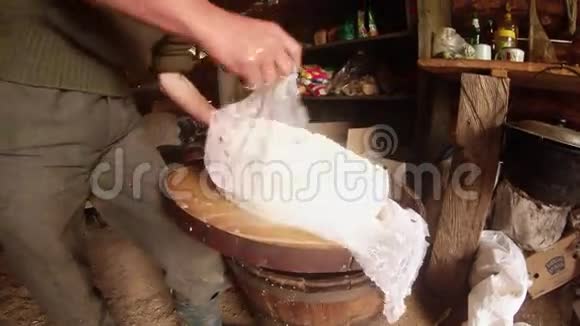 农夫手把热奶酪装在乳酪布里用来脱水牧羊人的小屋视频的预览图