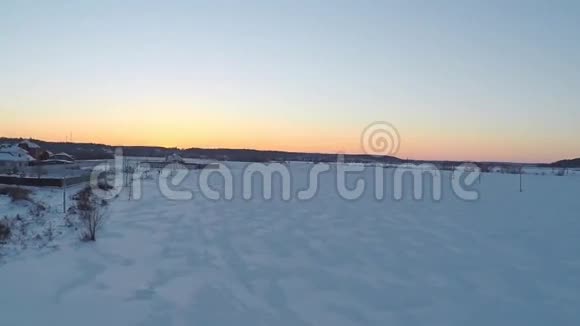 冬季日落时空中拍摄的小型电线塔架和远处别墅视频的预览图