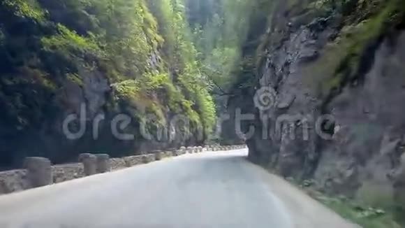 在高山峡谷的道路上行驶的汽车景观视频的预览图