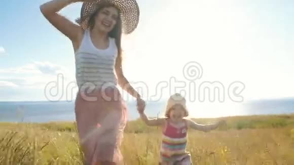 快乐的母亲和小女儿跑过田野视频的预览图