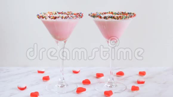 男人女人的手拿着粉红色的牛奶鸡尾酒特写上面装饰着果冻情人节视频的预览图