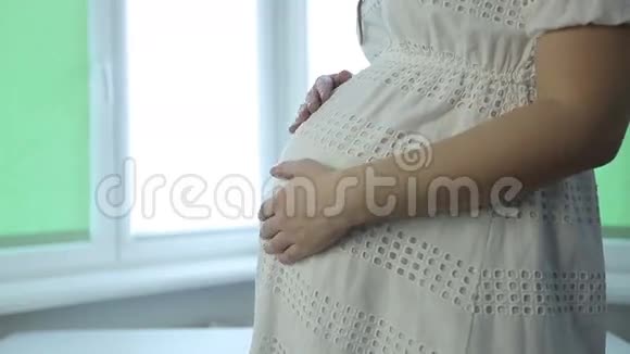 一个孕妇的特写镜头在抚摸着肚子视频的预览图