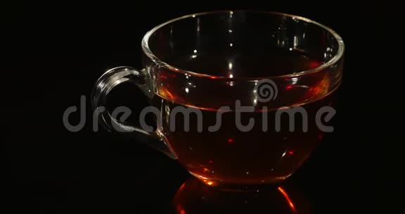 杯茶在黑色背景上旋转视频的预览图