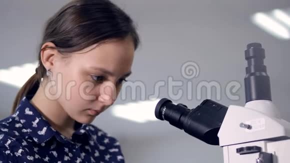 学校女生看显微镜特写镜头视频的预览图