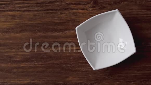 玉米片落在白色的碗里左边是木桌上的交叉空间视频的预览图