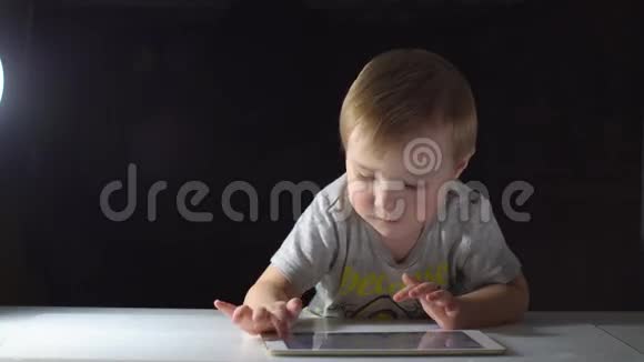 可爱的男孩在晚上使用平板电脑4K视频的预览图