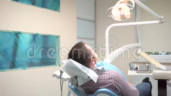 牙医坐下来检查病人的牙齿是的是的视频的预览图