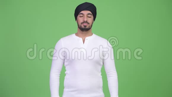 年轻快乐的留胡子的印度男人闭着眼睛放松视频的预览图