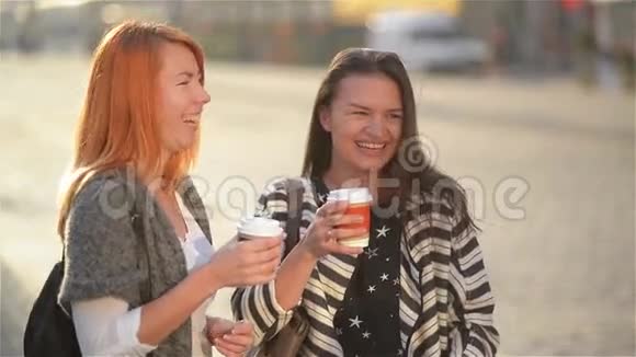 两个漂亮的年轻时尚女孩在户外玩得很开心迷人的年轻女性在夏季城市喝咖啡快乐视频的预览图