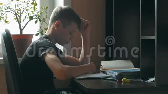 小男孩在做作业他坐在桌前学习写信小学生把预先写好的信和视频的预览图