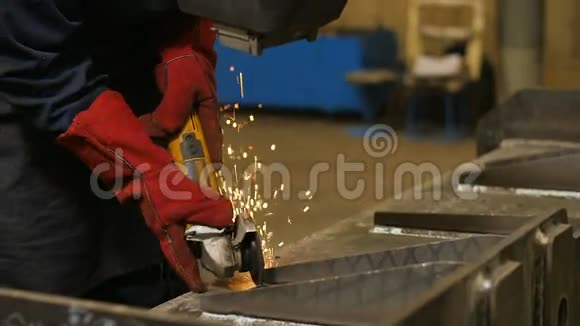 在金属结构金属上使用角磨机关闭面罩中的工人火花慢慢地转向相机慢慢视频的预览图