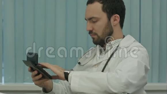 严重的男医生注重费用的计算视频的预览图