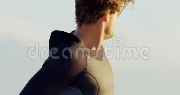 男子冲浪者在海滩上穿着潜水服视频的预览图