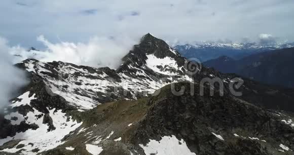 在晴朗的日子里在多云的多岩石雪山上俯视意大利阿尔卑斯山脉夏季与视频的预览图