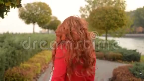 秋天公园里美丽的女人凉爽的风日视频的预览图