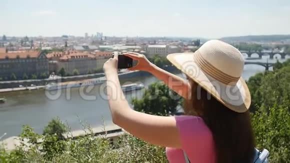 年轻女性在城市散步时在智能手机上拍照视频的预览图