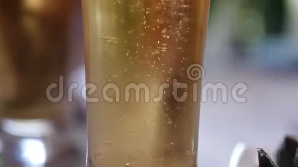 在装有水滴的玻璃杯里放冷光啤酒啤酒泡沫慢动作视频的预览图